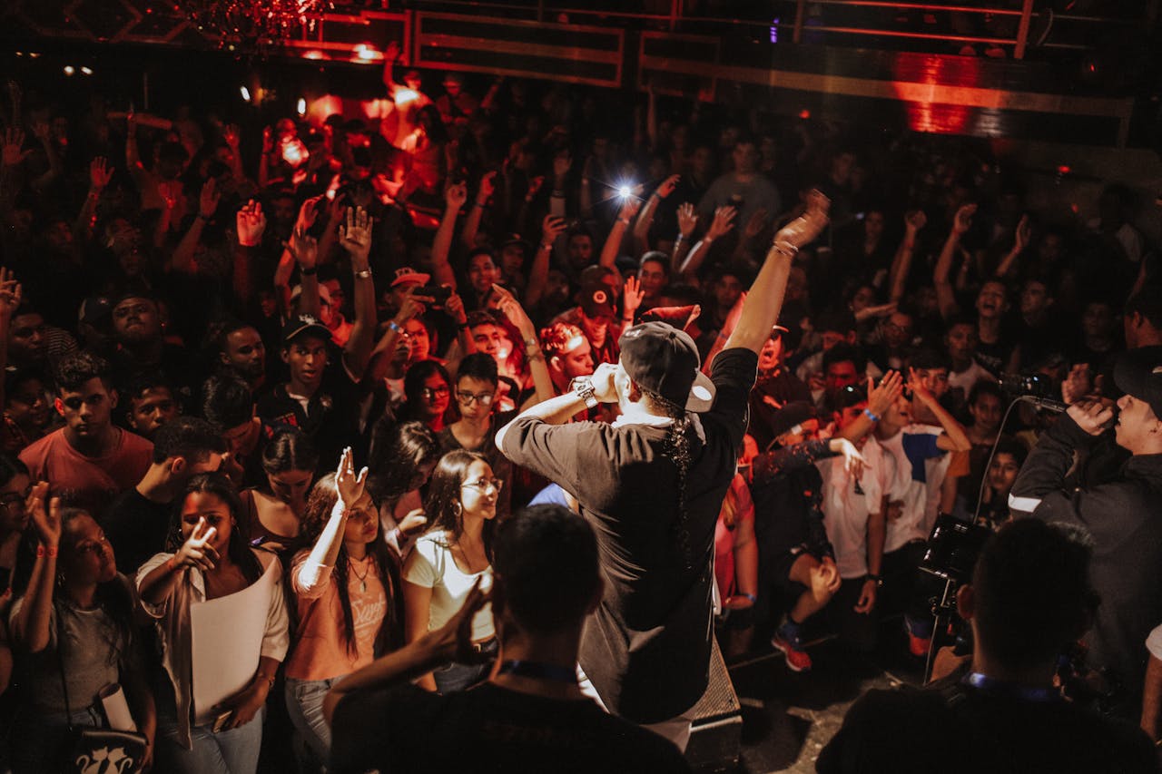 Vibrant rap concert with lively crowd and dynamic stage performance in a bustling nightclub atmosphere.